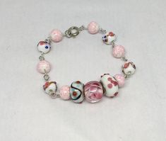 Whites, pinks & Blues in floral designs on glass & china beads on a vintage bead links chain. This bracelet is 7 1/2" long.   All proceeds from sales in this shop ,  --ForLydiaComfortDog -- go to the deployment fund of the North Boston Comfort team, enabling Lydia Comfort Dog & her Handlers to be deployed to sites of life's tragedies and bring the comfort of Christ to those affected. Lydia has a Facebook page we would love for you to go LIKE. Instagram and Twitter at lcck9lydia If you wish to make a donation, please make your check payable to North Boston Comfort, c/o Messiah Lutheran Church, 708 Lowell Street, Lynnfield, MA 01940.  You have our Thanks and blessings !! Pink Beaded Czech Glass Jewelry, Vintage Pink Bracelets With Round Beads, Pink Czech Glass Bracelets With Spacer Beads, Pink Czech Glass Bracelets With Colorful Beads, Vintage Pink Beaded Bracelet, Handmade Pink Czech Glass Bracelets, Vintage Pink Czech Glass Jewelry, Pink Czech Glass Bracelet, Pink Glass Jewelry With Colorful Beads