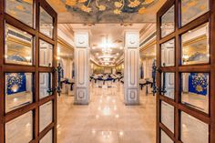 an open door leading to a dining room with blue and gold decorations on the ceiling