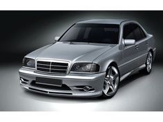 the front end of a silver car in a black background with red lettering on it