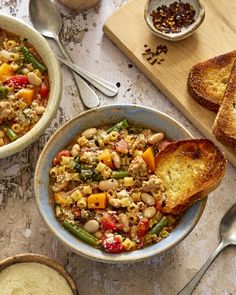 two bowls filled with food next to slices of bread