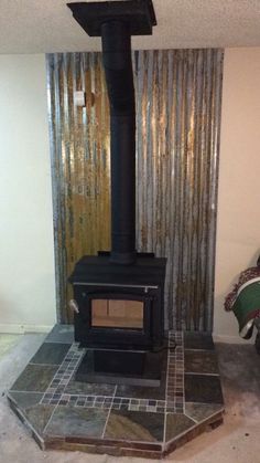 a black stove sitting inside of a living room next to a wall covered in curtains