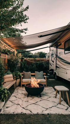 a camper trailer with a fire pit in the foreground