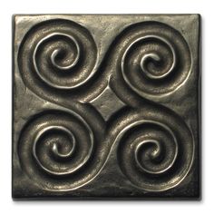 a square tile with swirls on it in bronze metal, against a white background