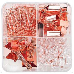 an assortment of copper colored paper clips and pins in a plastic box with clear lid