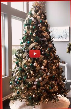 a decorated christmas tree in a living room with a red frame around it and a video play button