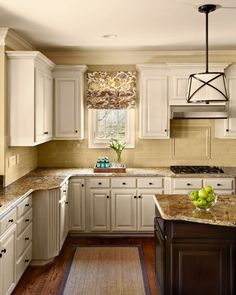 a kitchen with white cabinets and granite counter tops