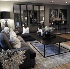 a living room with couches, tables and mirrors on the wall in it's center