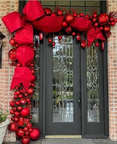 the front door is decorated for christmas with red ornaments and bows on it's side