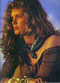 a close up of a person with long hair and jewelry on her neck wearing a necklace