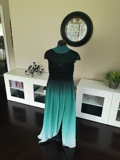 a dress on display in front of a wall clock