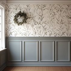 an empty room with wallpaper and a wreath hanging on the wall next to it