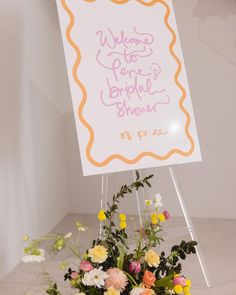 there is a sign that says welcome to the bridal shower on display with flowers