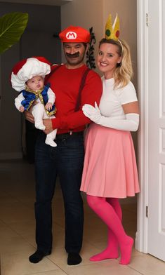 a man and woman are dressed up as mario and princess peaches with a baby