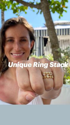 a woman pointing at the camera with her hand in front of her and wearing a gold ring