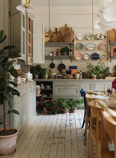 a kitchen filled with lots of pots and pans next to a dining room table