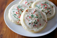 some white cookies with sprinkles on a plate