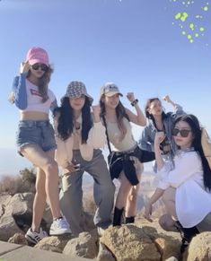 the girls are posing on top of some rocks