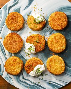 several crab cakes on a plate with sour cream