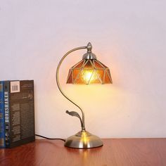 a lamp on a table next to a book