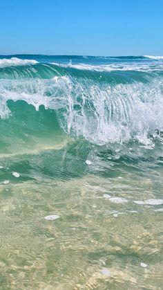 an ocean wave is breaking on the beach