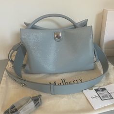 Stunning Brand New Cloud Blue Mulberry Spongy Patent Leather Tote Bag With Thin Strap ($2,050 + Tax) Plus Cloud Blue Mulberry Triple Lock Strap ($450 + Tax) Iris Bag Details: 100% Bovine Leather; Lining 100% Suede Magnetic Closure Top Handle, Detachable Adjustable Shoulder Strap, All Over Wrinkled Patent Finish, Foiled Debossed Brand Signature At Front, Ties At Sides, Metal Feet At Base, Silver-Toned Hardware, One Main Compartment, Interior Zip Pocket And Slip Pocket Height 23cm, Width 33cm, Dep Mulberry Iris, Mulberry Bag Alexa, Camel Leather Bag, Alexa Bag, Mulberry Handbags, Mulberry Bag, Brown Satchel, Patent Leather Bag, Bag Details