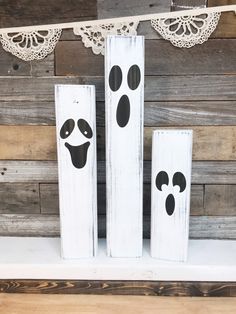 two wooden blocks with faces painted on them, one is white and the other is black