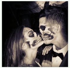 a couple dressed up as skeletons kissing each other