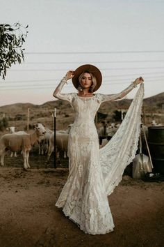 a woman in a white dress and cowboy hat