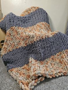 a crocheted blanket is laying on the floor