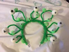 a group of fake eyeballs on top of a white sheet with green thread and plastic eyes