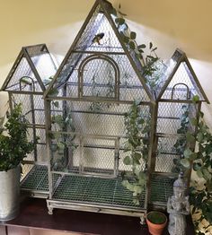 a metal bird cage with plants in it