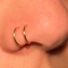 the nose has two small gold hoops on it