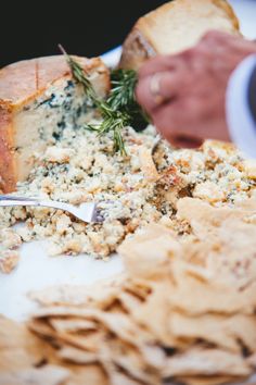 a plate with some food on it and a person holding a fork next to it