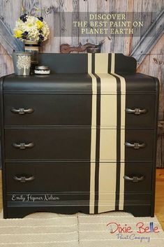 the dresser is painted black and white with an interesting striped stripe on it's side