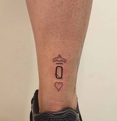 a person with a tattoo on their leg that has the letter o and crown in it