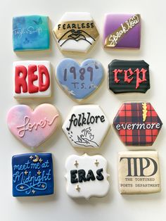 many different decorated cookies are arranged on a white surface with red, blue, and black lettering