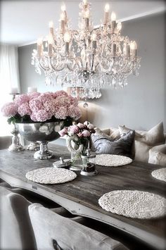 a dining room table with flowers and chandelier