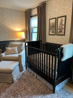 a baby crib in the corner of a living room with a couch and chair