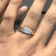 a woman's hand with an engagement ring on top of her finger and two diamonds in the middle