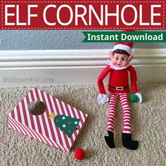 an elf doll sitting next to a christmas gift bag with the words elf cornhole on it