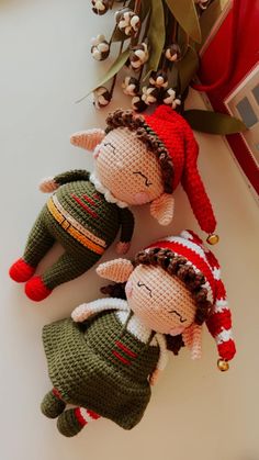 two knitted dolls laying next to each other on top of a white countertop