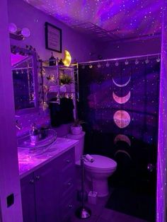 a bathroom with purple lights on the ceiling and shower curtain over the toilet in it