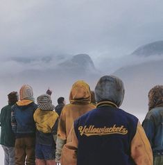 a group of people standing next to each other on top of a snow covered slope