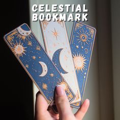 the celestial bookmark is being held in front of a window