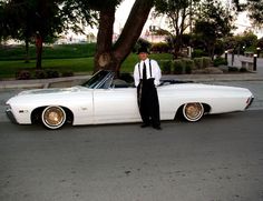 a man standing next to a white car