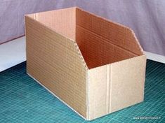 an open cardboard box sitting on top of a blue tile floor next to a wall