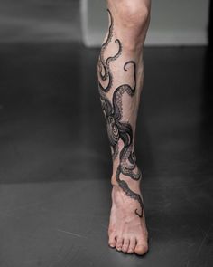 a man's legs with an octopus tattoo on the bottom part of his leg