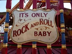 an old rock and roll sign hanging off the side of a building