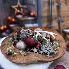 a wooden bowl filled with ornaments on top of a table