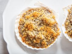 two baked desserts on a white plate with crumbs